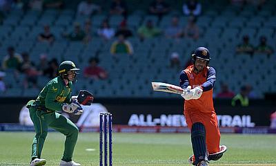 The Netherlands' Tom Cooper plays a shot over the boundary line for six runs watched by South Africa's wicketkeeper Quinton de Kock (L) during their m