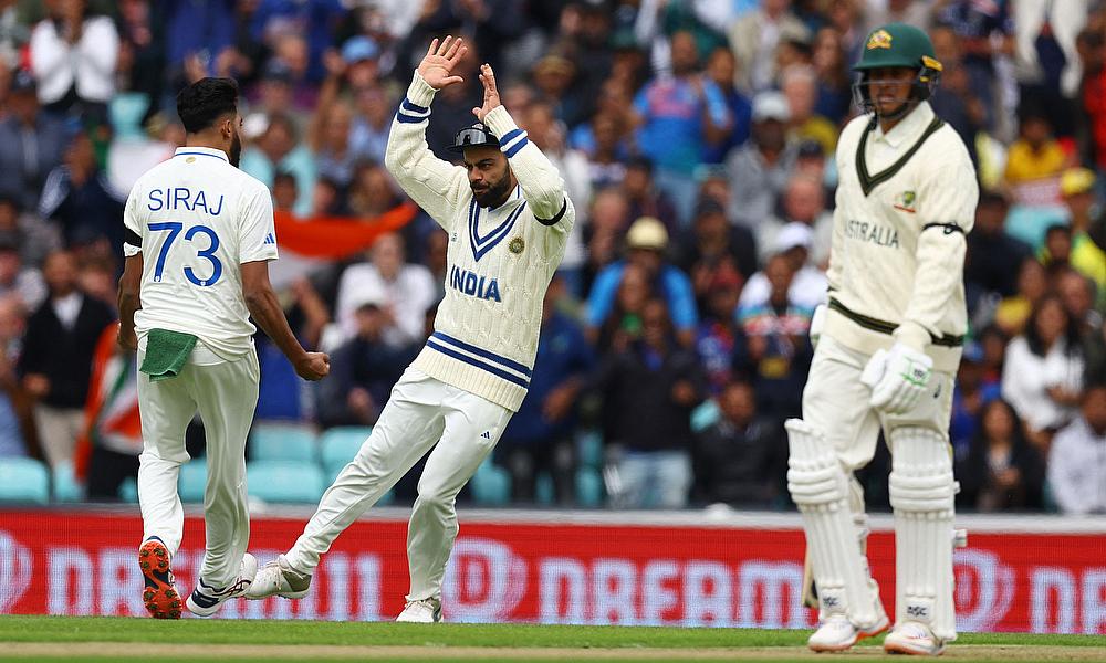 India's Mohammed Siraj celebrates after taking the wicket of Australia's Usman Khawaja with Virat Kohli